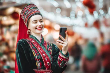 A man celebrating a winning moment on his laptop while gaming symbols float around him, capturing the excitement of 2G777 games.